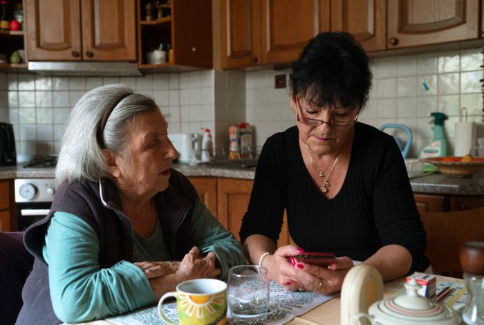 A caregiver and senior together in a home kitchen