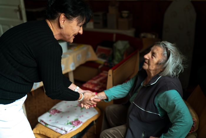 A caregiver warmly greeting a senior at home